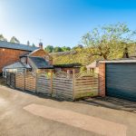 Charming cottage with garage and wooden fence.