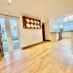 Spacious kitchen with wooden floors and glass doors.