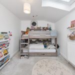 Children's bedroom with bunk bed and bookshelves.