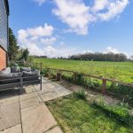Patio view of green field and blue sky.