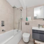Modern bathroom with shower, toilet, and sink.