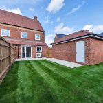 Modern brick house with green lawn and patio.