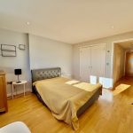 Bright bedroom with wooden flooring and double bed.