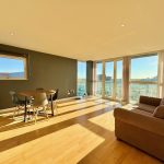 Bright living room with dining area and large windows.