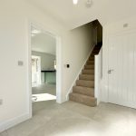 Modern hallway with stairs and bright lighting.