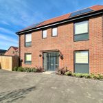 Modern red brick house with solar panels.