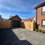 Brick house with driveway and garage in new development.