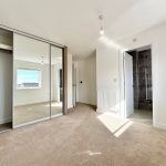 Empty room with mirrored wardrobe and en-suite bathroom.