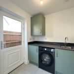 Modern utility room with washing machine and sink.