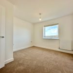 Empty room with carpet and window view.