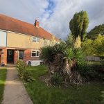 Suburban house with front garden and pathway.