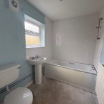 Plain bathroom with white tiles and blue walls.