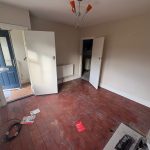 Empty room with wooden floor and open doors.