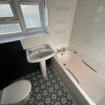 Small bathroom with bath, sink, and toilet.