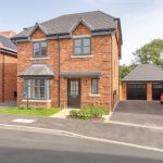 Modern brick house with double garage and car.