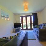 Spacious living room with sofas and garden view.