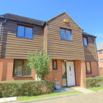 Two-storey red brick and wood house exterior.