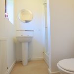 Small bathroom with sink, toilet, and mirror.
