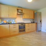 Spacious kitchen with wooden cabinets and appliances.