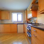 Modern kitchen with wooden cabinets and gas stove.