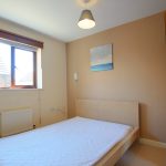 Small bedroom with a bed and window.