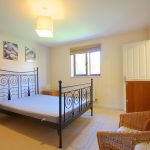 Cosy bedroom with double bed and neutral decor.