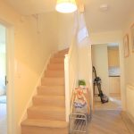 Bright hallway with stairs and doors