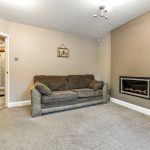 Living room with sofa and wall-mounted fireplace.