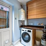 Utility room with washing machine and heater.