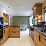 Modern kitchen interior with wooden cabinets and dining area.