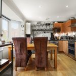 Modern kitchen with wooden cabinets and dining table.