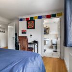Bedroom with adjoining bathroom and desk area.