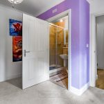 Bedroom with ensuite shower and purple walls.