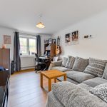 Cosy living room with sofa and desk.