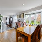 Bright dining room with large windows and plants.