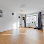 Bright living room with wooden floors and large window.