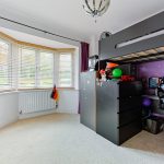 Children's bedroom with bunk bed and purple curtains.