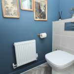 Modern blue bathroom with toilet and radiator.