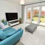 Modern living room with blue sofa, garden view.