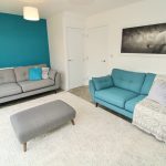 Modern living room with teal and grey sofas.