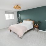 Modern bedroom with green accent wall.