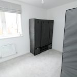 Bright room with covered wardrobe and window.