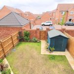 Back garden with wooden fence and shed.