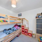 Children's room with bunk bed and storage stairs.