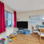 Cosy room with red curtains and wooden furniture.