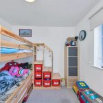 Children's room with bunk bed and storage boxes.