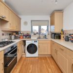 Modern kitchen with wooden cabinets and appliances.