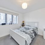 Modern bedroom with star-curtain and white furniture.