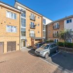 Brick apartment building with parked cars outside.