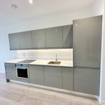 Modern grey kitchen cabinets with integrated appliances.